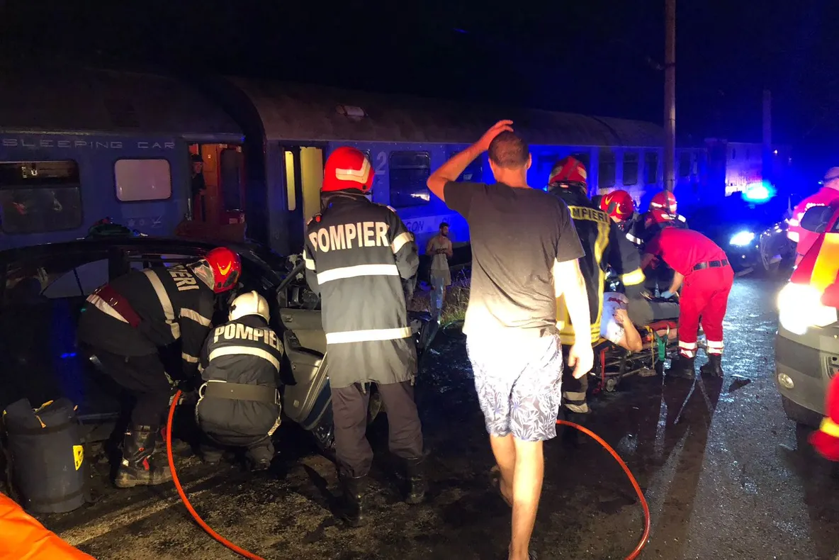 Mașină lovită de locomotiva unui tren în județul Bistrița-Năsăud. Trei persoane sunt prinse între fiarele contorsionate ale mașinii (FOTO)