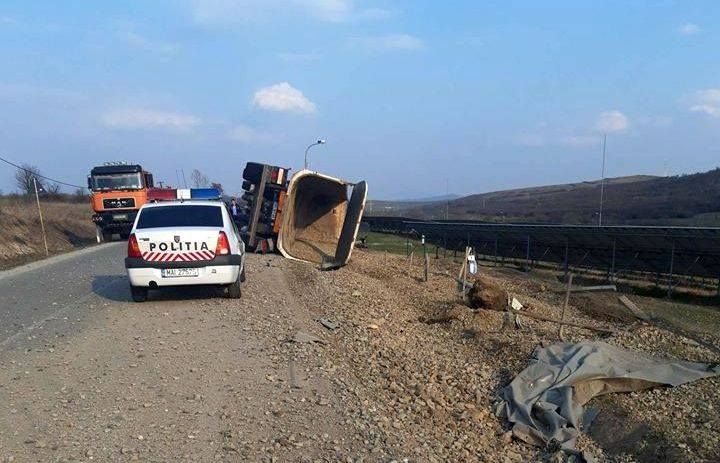 FOTO: Camion plin cu pietriș, răsturnat pe o șosea din Bistrița-Năsăud, după o explozie a unui cauciuc! Șoferul a ajuns la spital