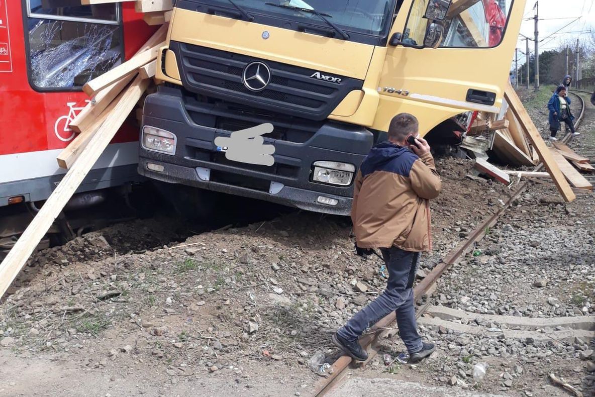 FOTO: TIR lovit de un tren personal, în care se aflau 60 de persoane, la Beclean! Sunt persoane rănite