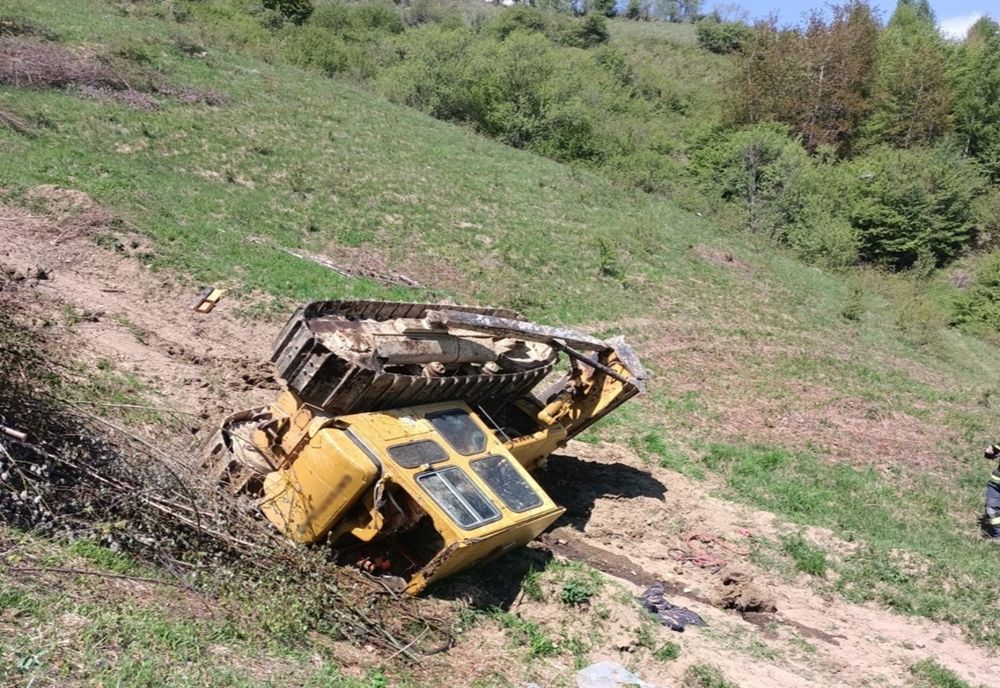 Buldozer răsturnat pe un deal din Maieru! Șoferul a fost transportat la spital